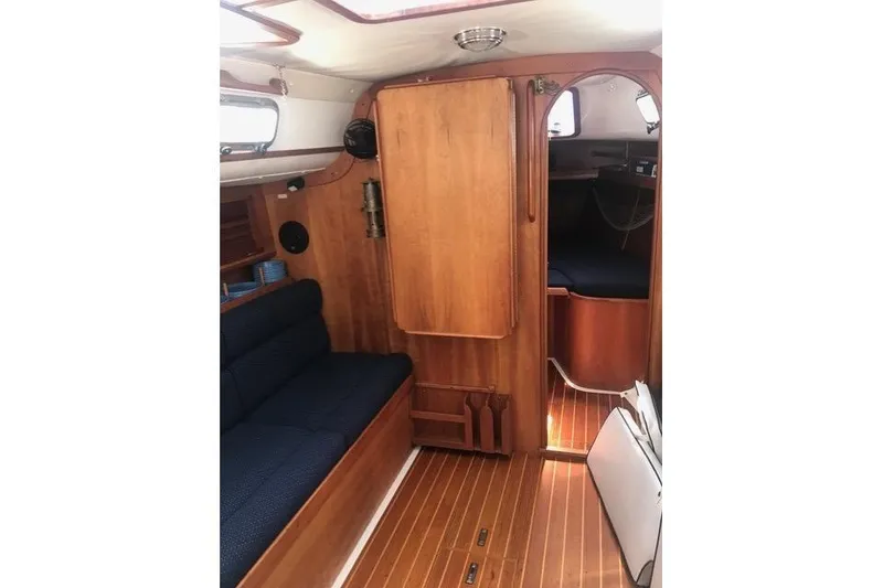 Slide: The Image of Interior of a 1996 Freedom 35 sailboat with wooden furnishings and blue seating. - 8