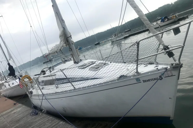 Slide: The Image of 1988 Beneteau First 285 sailboat docked at a marina on a cloudy day. - 2