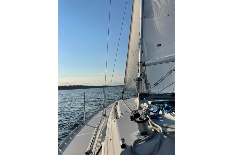 Slide: The Image of Sailing on a 1988 Beneteau First 285 yacht, with clear skies and calm waters. - 4