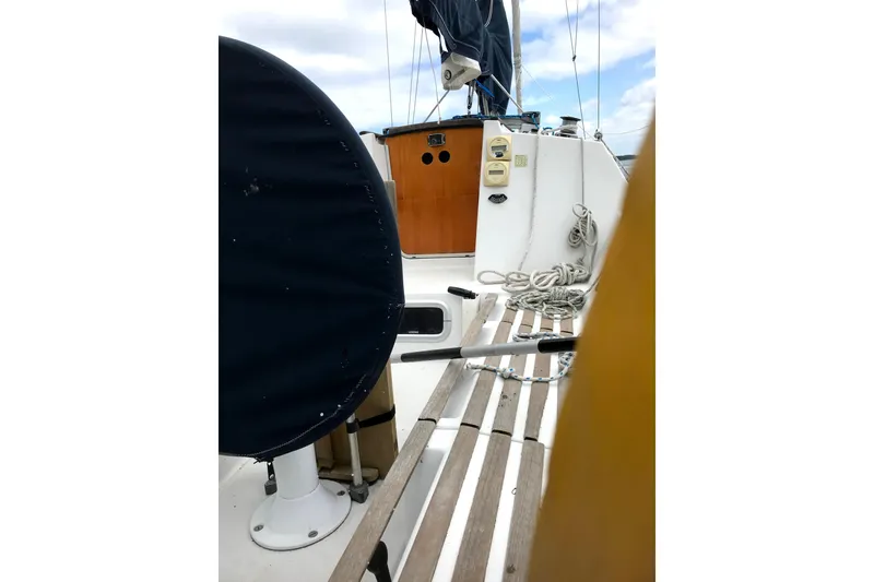 Slide: The Image of 1988 Beneteau First 285 sailboat cockpit with wooden seating and nautical equipment. - 5