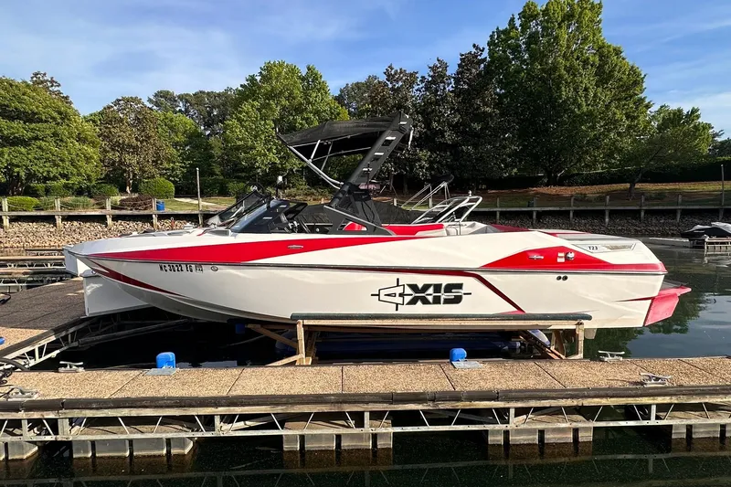 The Image of 2017 Axis T23 boat docked on a sunny day with lush greenery in the background. - 0