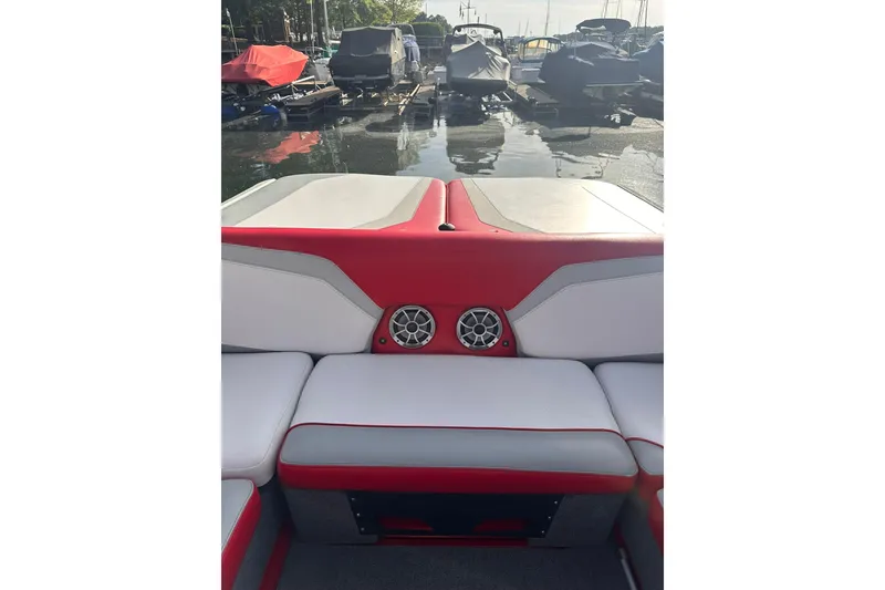 Slide: The Image of 2017 Axis T23 boat interior with red and white seating, docked at marina. - 3