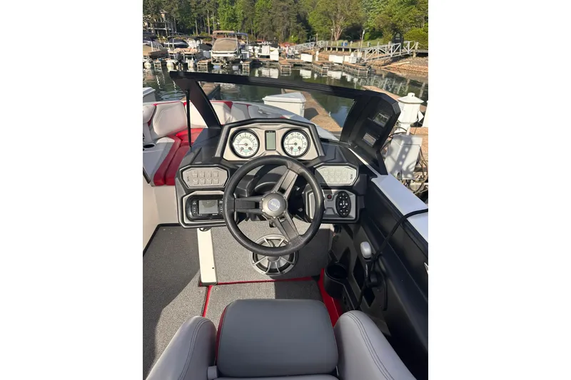 Slide: The Image of 2017 Axis T23 boat dashboard with steering wheel and gauges at marina. - 8