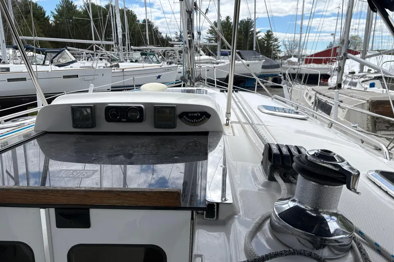 Slide: The Image of 2009 Hunter 41 Deck Salon sailboat docked among other vessels, showcasing deck and winch. - 11