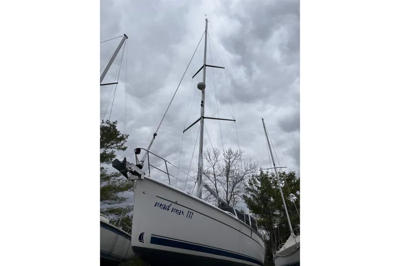 Slide: The Image of 2009 Hunter 41 Deck Salon sailboat with tall mast under cloudy sky. - 2