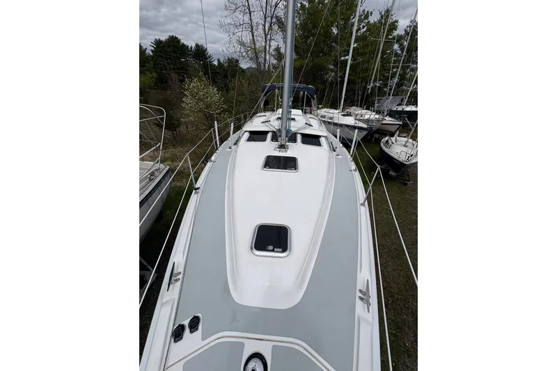 Slide: The Image of 2009 Hunter 41 Deck Salon sailboat, docked with surrounding trees and overcast sky. - 27