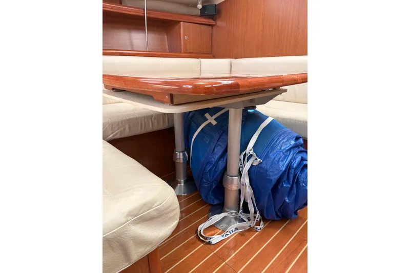 Slide: The Image of 2009 Hunter 41 Deck Salon interior with wooden table and blue sail storage. - 40