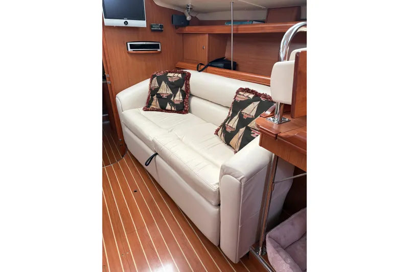 Slide: The Image of Interior of 2009 Hunter 41 Deck Salon with white sofa and nautical-themed pillows. - 41