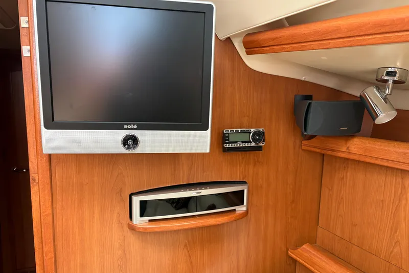 Slide: The Image of 2009 Hunter 41 Deck Salon interior with TV, stereo, and speaker system. - 49