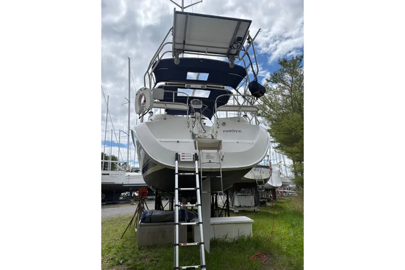 Slide: The Image of 2009 Hunter 41 Deck Salon sailboat on land with ladder access, under cloudy sky. - 5