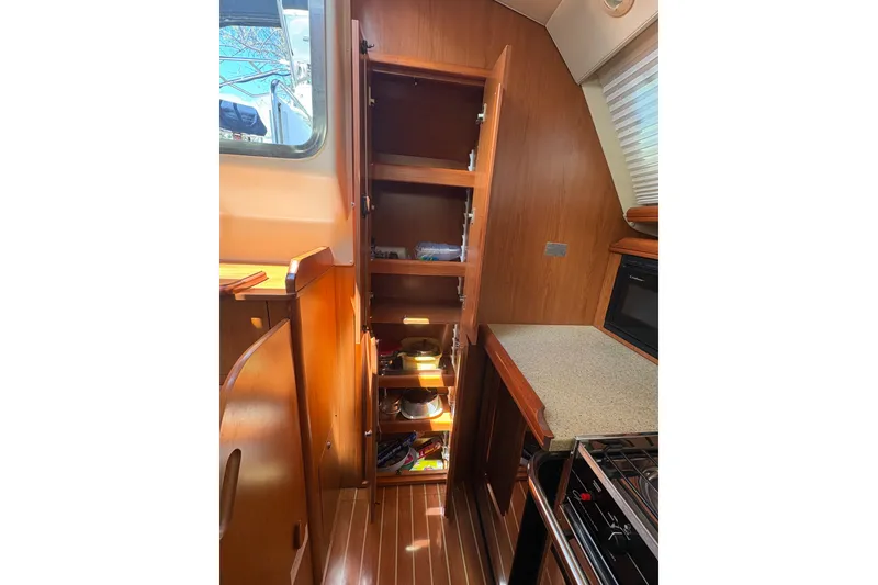 Slide: The Image of 2009 Hunter 41 Deck Salon interior kitchen with open wooden cabinets and modern appliances. - 58