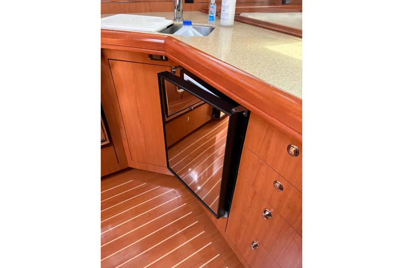 Slide: The Image of 2009 Hunter 41 Deck Salon interior with open fridge and wooden cabinetry. - 63