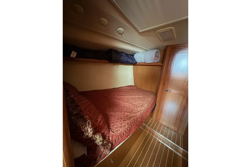 Slide: The Image of Cozy cabin interior of 2009 Hunter 41 Deck Salon with wooden finishes and red bedding. - 74