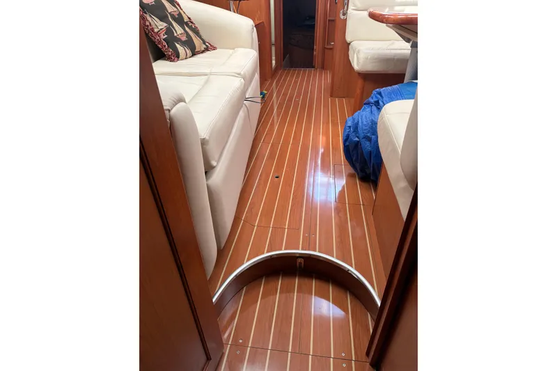 Slide: The Image of Interior of 2009 Hunter 41 Deck Salon with polished wood flooring and white seating. - 85