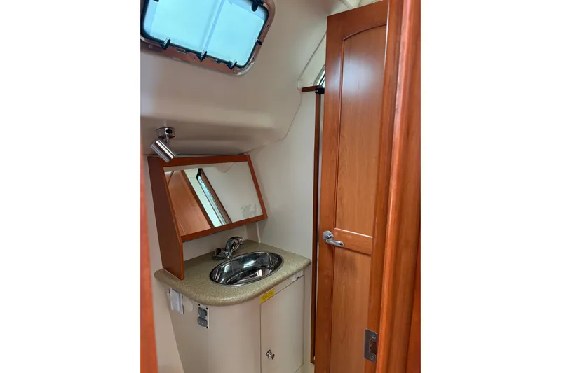Slide: The Image of 2009 Hunter 41 Deck Salon bathroom with sink, mirror, and wooden cabinetry. - 95