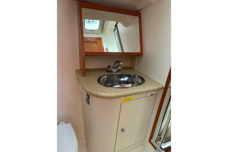 Slide: The Image of 2009 Hunter 41 Deck Salon bathroom sink with mirror and storage cabinet. - 96