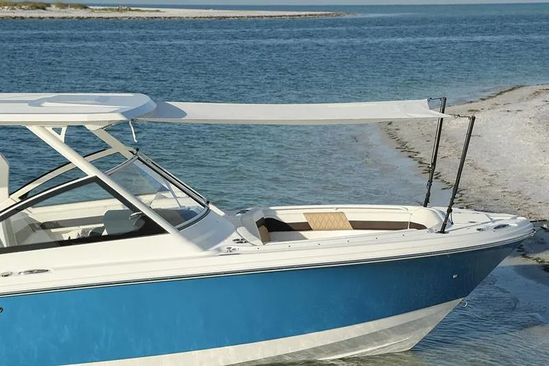 Slide: The Image of Manufacturer Provided Image: 2026 Edgewater 262CX Crossover boat with blue hull, anchored near sandy shore. - 2