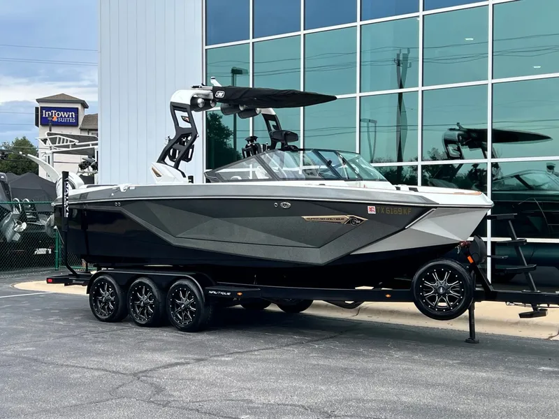 The Image of 2021 Nautique G23 boat on trailer in front of building. - 1