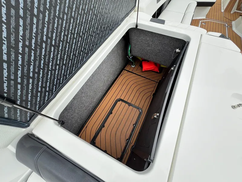 Slide: The Image of Storage compartment in 2021 Nautique G23 boat with wood flooring. - 13