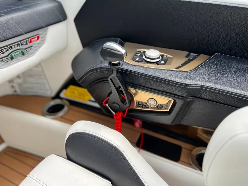 Slide: The Image of Interior of a 2021 Nautique G23 boat with control console. - 26