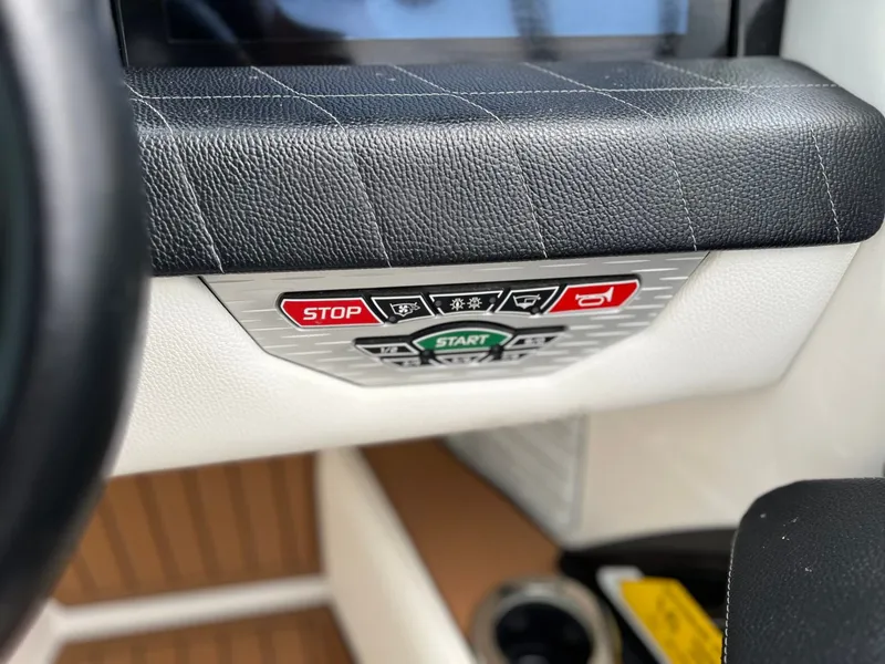 Slide: The Image of 2021 Nautique G23 boat controls with start and stop buttons. - 28