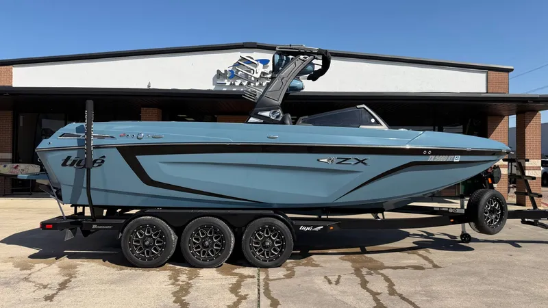 The Image of 2022 Tigé 25ZX boat on trailer in front of building. - 1