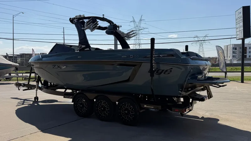 Slide: The Image of 2022 Tigé 25ZX boat parked on a trailer outdoors. - 5