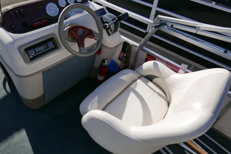 Slide: The Image of 2004 Sun Tracker Party Barge 240 helm with steering wheel and comfortable captain's chair. - 10