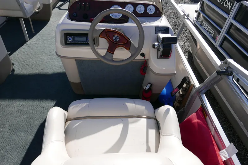Slide: The Image of 2004 Sun Tracker Party Barge 240 helm with steering wheel and control panel. - 11