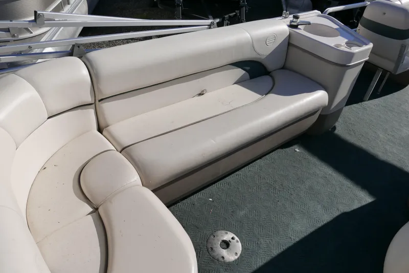 Slide: The Image of 2004 Sun Tracker Party Barge 240 interior with beige seating and cup holders. - 12