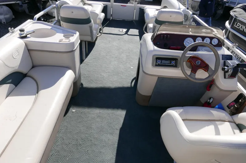 Slide: The Image of 2004 Sun Tracker Party Barge 240 interior with seating and helm controls. - 13