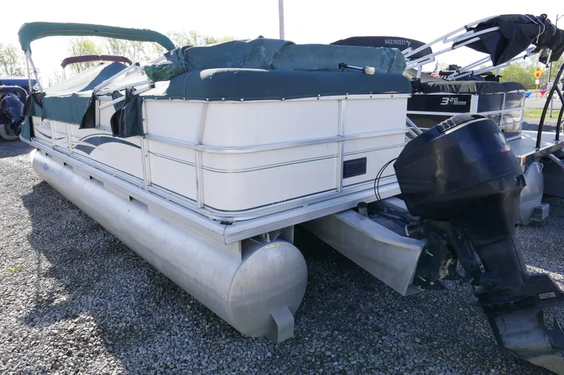 Slide: The Image of 2004 Sun Tracker Party Barge 240 pontoon boat with outboard motor on gravel. - 3