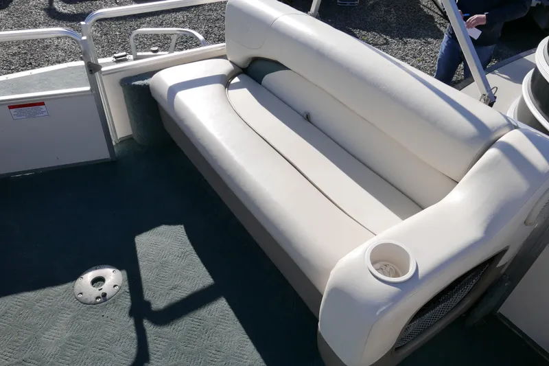 Slide: The Image of 2004 Sun Tracker Party Barge 240 interior with cushioned seating and cup holder. - 6