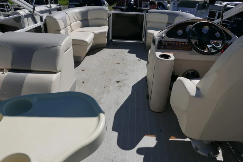 Slide: The Image of Interior of a 2022 Lexington 320HPT pontoon boat with beige seating and steering console. - 12