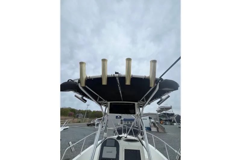 Slide: The Image of 2002 Hydra-Sports 230 CC boat with T-top and rod holders, docked under cloudy sky. - 12