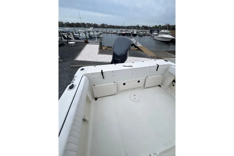 Slide: The Image of 2002 Hydra-Sports 230 CC boat docked at marina, showcasing spacious deck and outboard motor. - 17