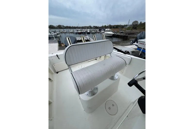 Slide: The Image of 2002 Hydra-Sports 230 CC boat interior with white seating, docked at a marina. - 18