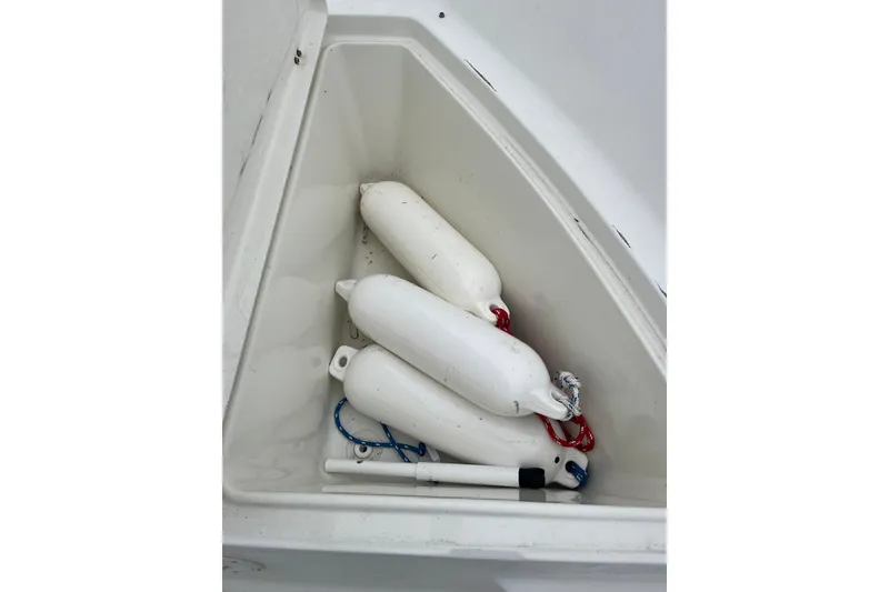 Slide: The Image of Storage compartment with white boat fenders on a 2002 Hydra-Sports 230 CC. - 19