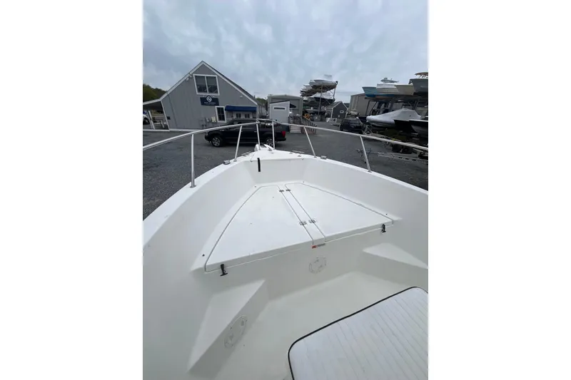 Slide: The Image of 2002 Hydra-Sports 230 CC boat at a marina, showcasing bow and storage area. - 2