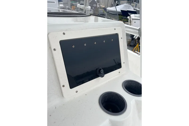 Slide: The Image of Console of a 2002 Hydra-Sports 230 CC boat with cup holders and a black panel. - 4