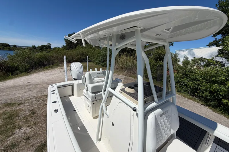 Slide: The Image of 2026 Pathfinder 2400 Open boat with T-top, parked near a scenic waterway. - 10