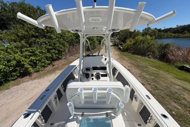 Slide: The Image of 2026 Pathfinder 2400 Open boat with T-top, rod holders, and spacious deck near a scenic waterway. - 11