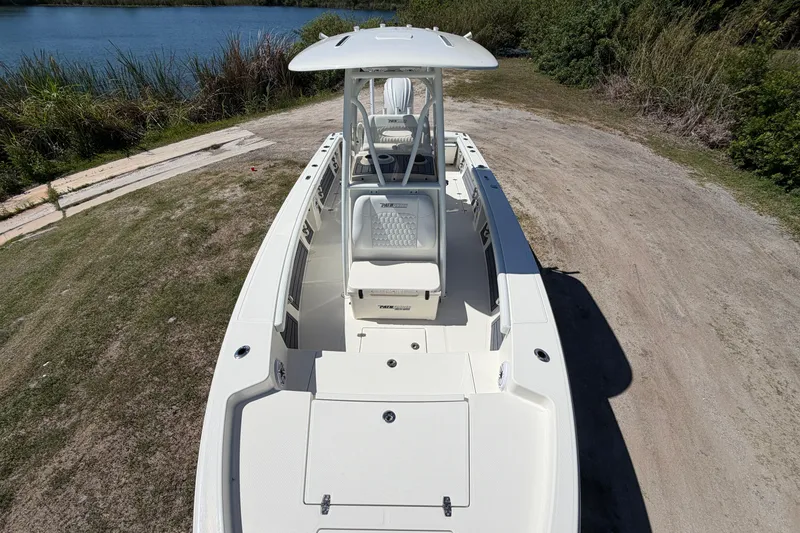Slide: The Image of 2026 Pathfinder 2400 Open boat on a grassy shore near a lake. - 7