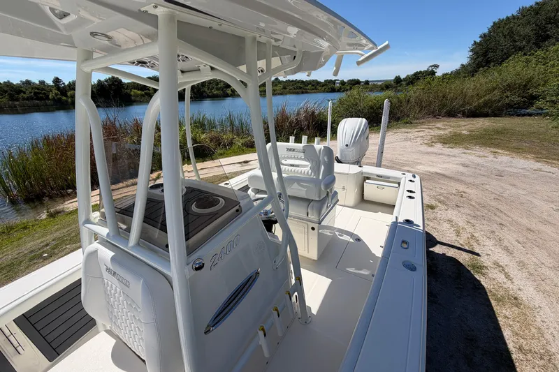 Slide: The Image of 2026 Pathfinder 2400 Open boat docked by a scenic lakeside with lush greenery. - 9
