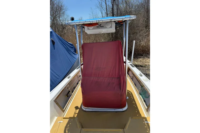 Slide: The Image of 2017 Mako 21 LTS boat with red cover, parked outdoors. - 3