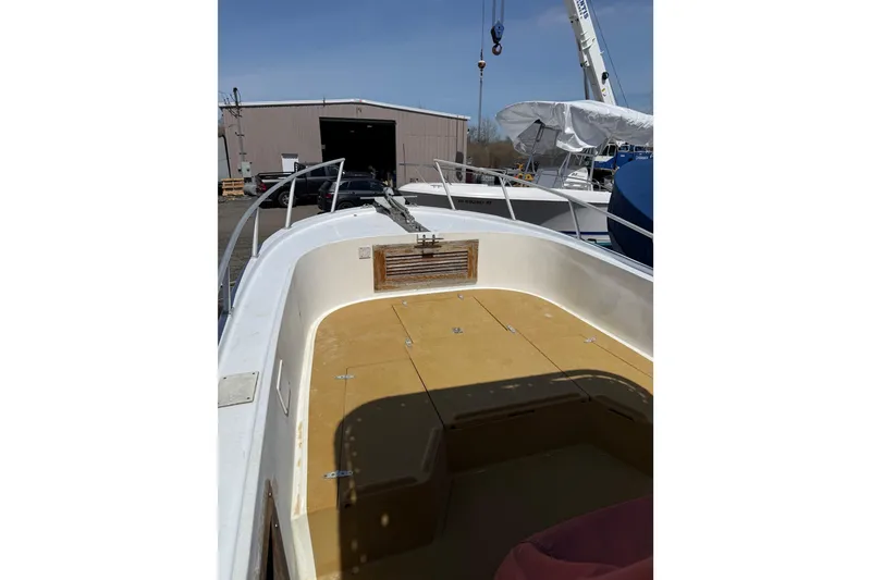 Slide: The Image of 2017 Mako 21 LTS boat deck in a marina, with storage compartments visible. - 4