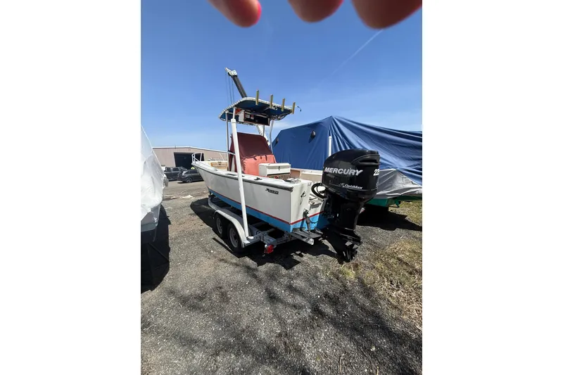 Slide: The Image of 2017 Mako 21 LTS boat with Mercury engine on trailer, parked outdoors. - 5