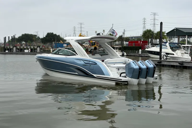 Slide: The Image of 2026 Formula 360 Crossover Bowrider OB in marina, featuring sleek design and triple outboard engines. - 10