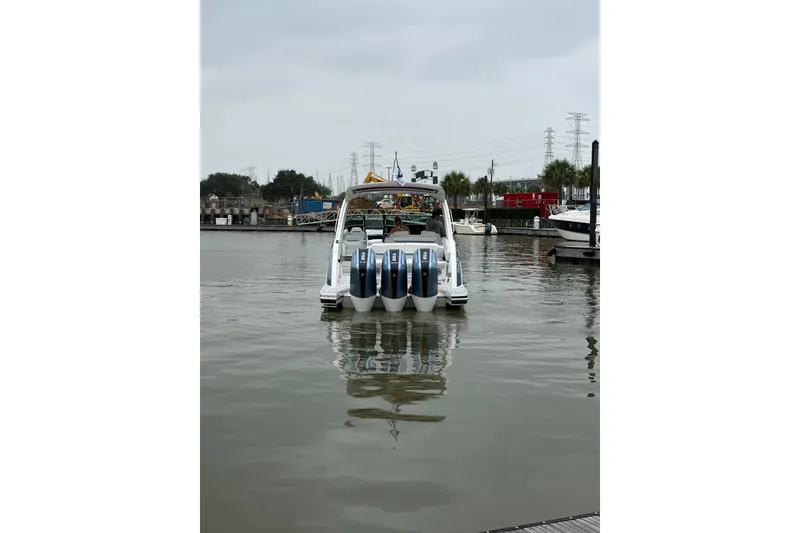 Slide: The Image of 2026 Formula 360 Crossover Bowrider OB in marina, rear view with multiple outboard engines. - 12