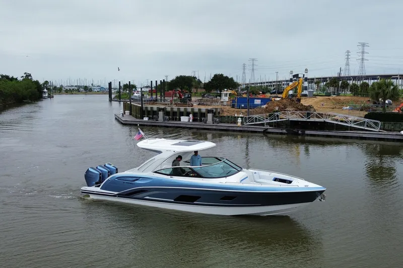 Slide: The Image of 2026 Formula 360 Crossover Bowrider OB cruising on a calm river near a construction site. - 18
